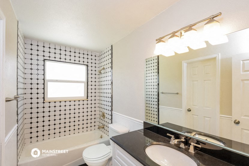 a bathroom with a shower toilet and sink and a mirror