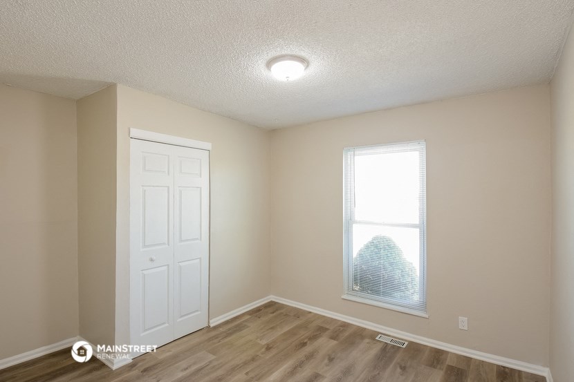 the interior of an empty room with a window and a white door