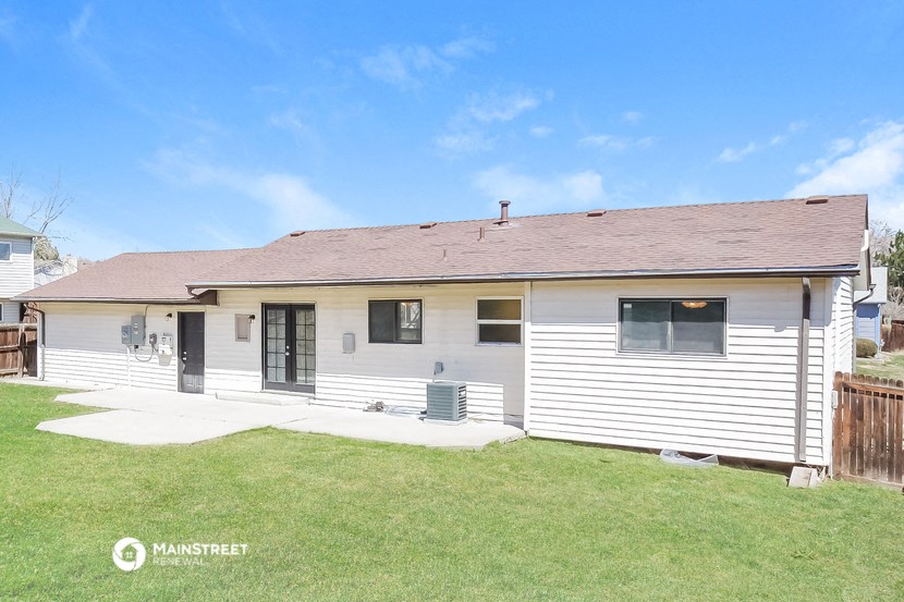 a small white house with a porch and a yard