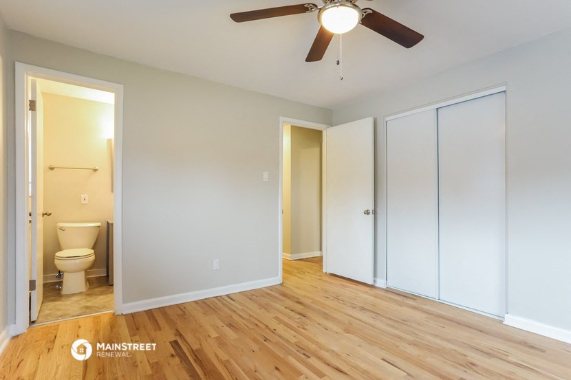 an empty room with a ceiling fan and a toilet