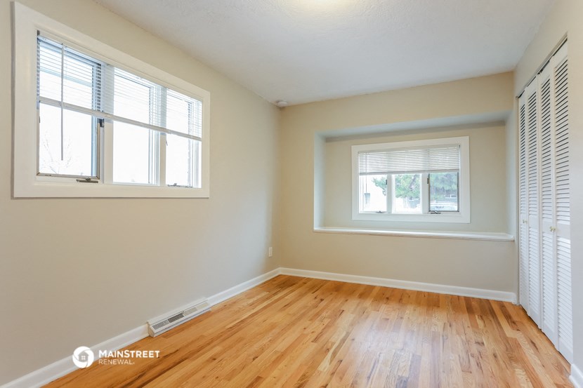 the living room of a house with wood floors and a window