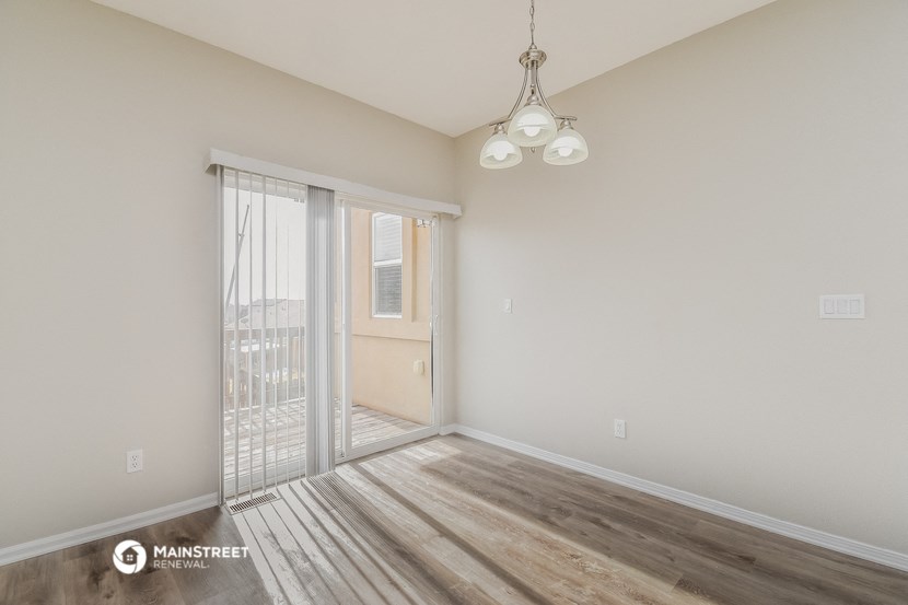 a spacious living room with a sliding glass door to a balcony