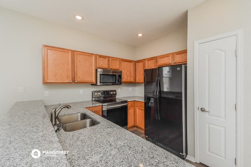 a kitchen with granite counter tops and black appliances