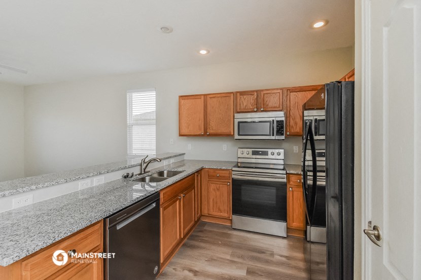 a kitchen with wood cabinets and granite counter tops and stainless steel appliances