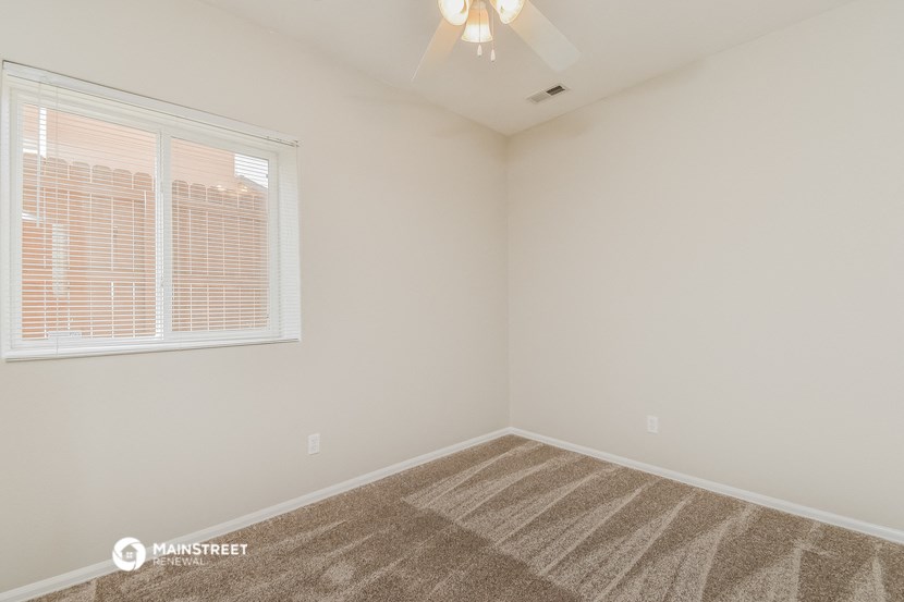 the spacious living room of a manufactured home with carpet and a large window
