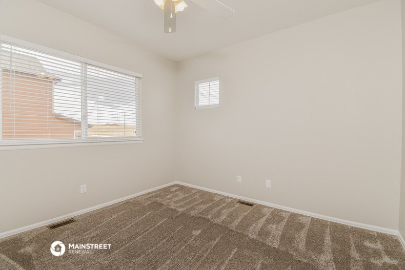 the spacious living room of a manufactured home with a large window and carpet