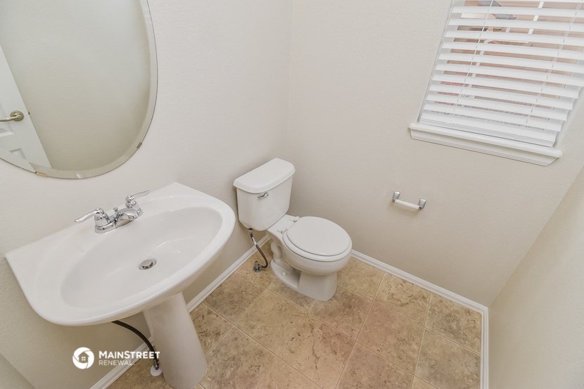 a bathroom with a toilet and a sink and a mirror