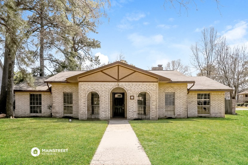 the front of a brick house with a walkway and grass