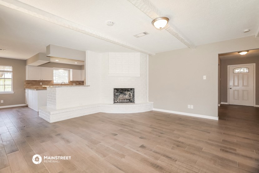 a living room with a fireplace and a kitchen