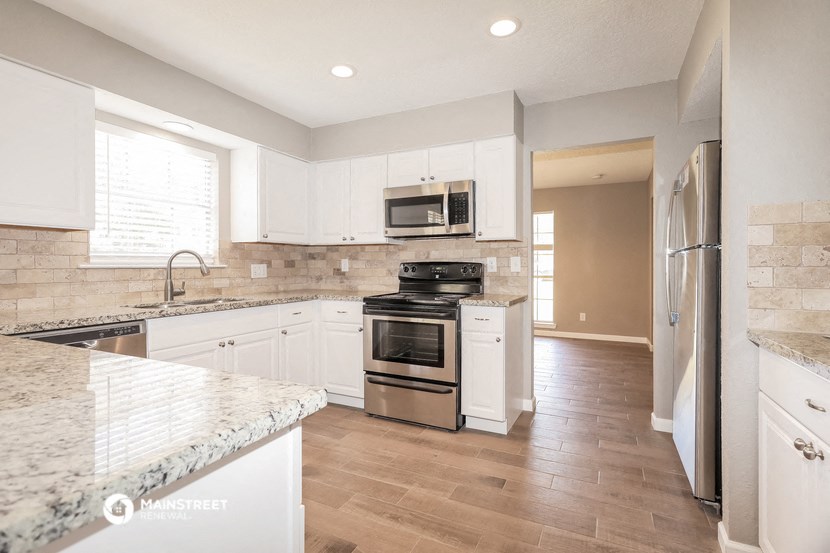 a kitchen with white cabinets and stainless steel appliances