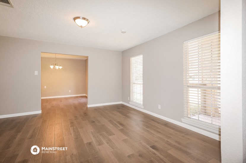 the spacious living room with wood flooring and large windows