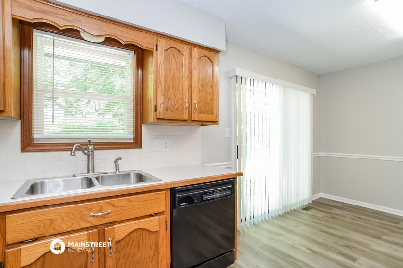 a kitchen with wooden cabinets and a sink and a window