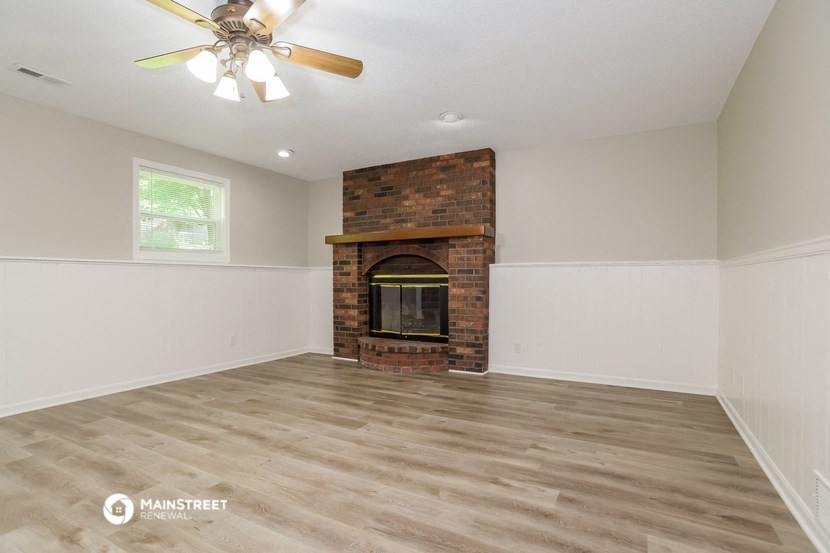 the living room with fireplace and wood flooring