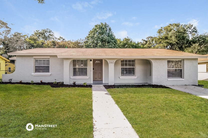 a white house with a lawn and a sidewalk