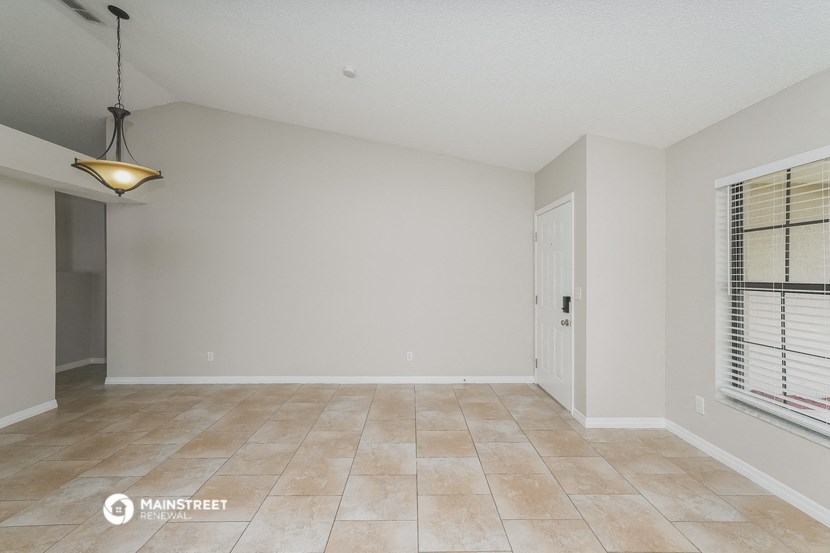 the spacious living room with a large window and tile flooring