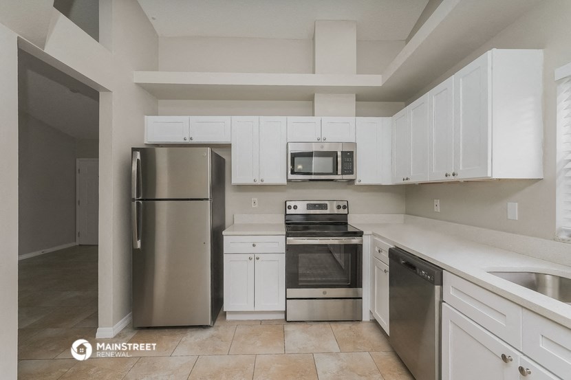 a kitchen with white cabinets and stainless steel appliances