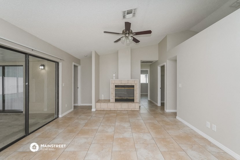 a living room with a fireplace and a ceiling fan
