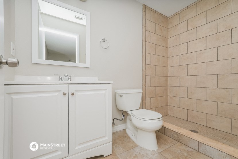 a bathroom with a toilet and a sink and a mirror