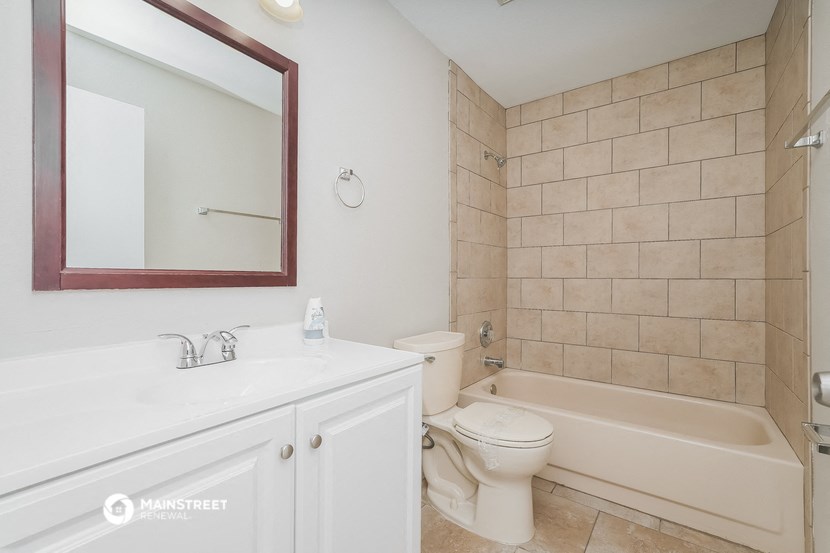 a bathroom with a bath tub and a sink and a toilet