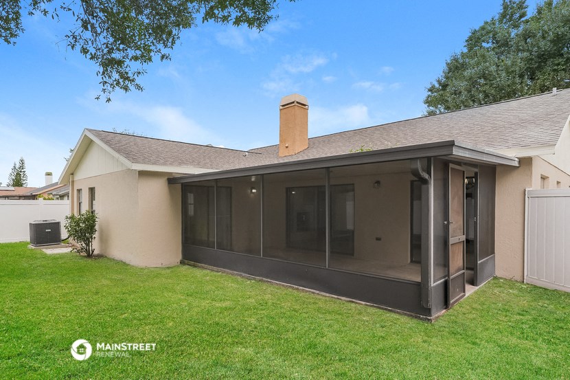 the backyard of a house with a lawn and a patio