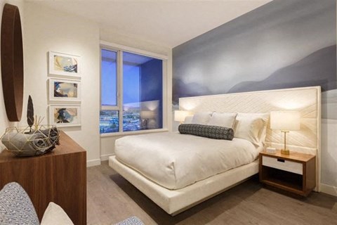 A bedroom with a large bed and a surfboard on the wall.