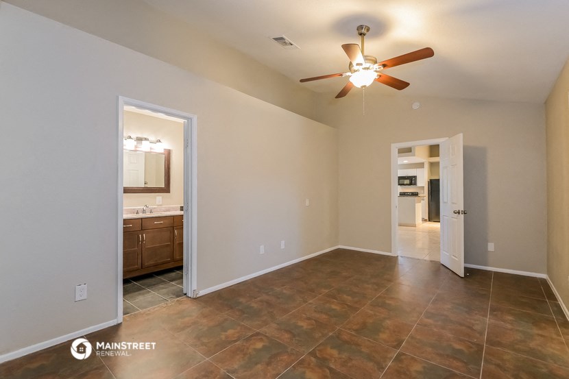 the spacious living room with tile flooring and a ceiling fan