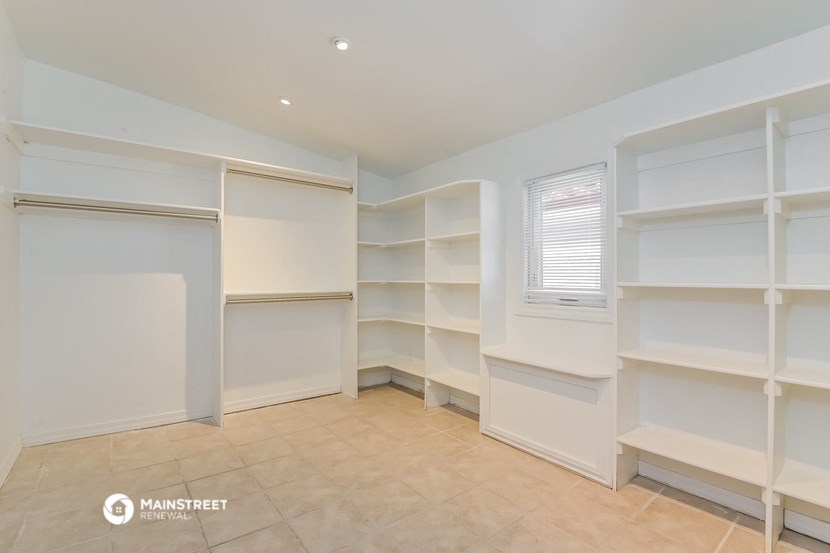 a walk in closet with shelving and a window
