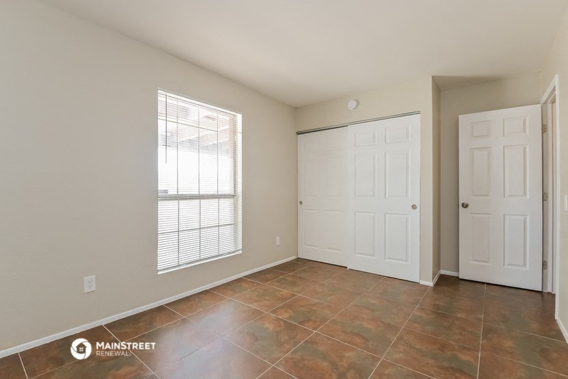 the spacious living room with two closets and tiled floors