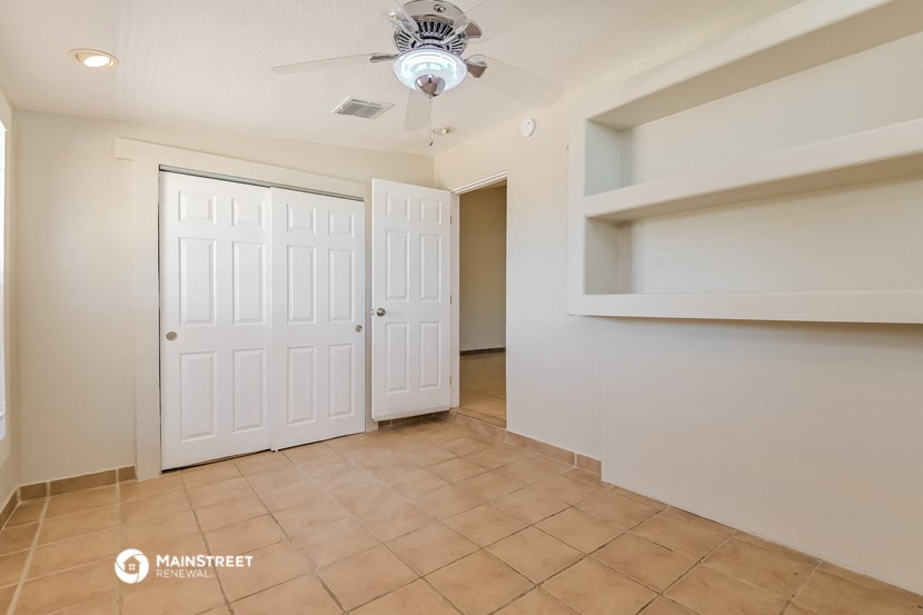 a living room with two closets and a ceiling fan