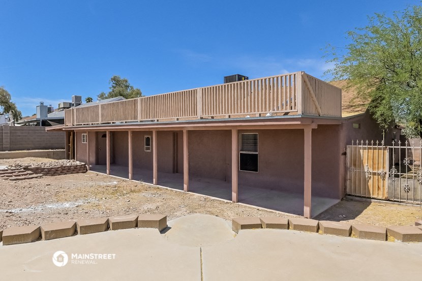 a view of the back of a building with a deck on top of it
