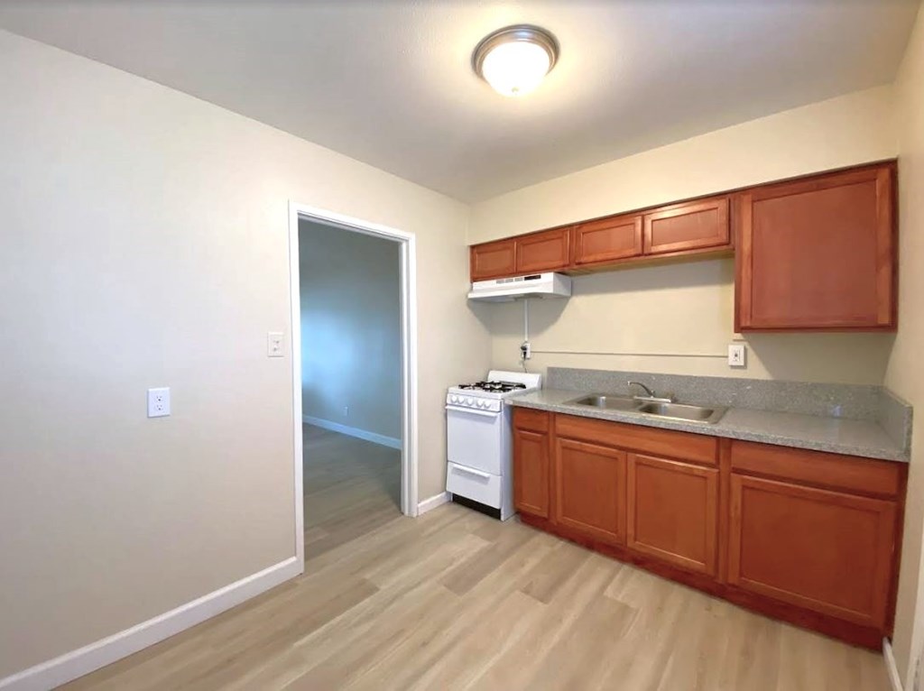 A kitchen with wooden cabinets and a white dishwasher.