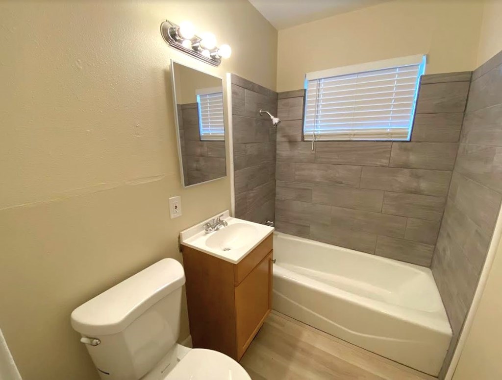 A bathroom with a toilet, sink, and bathtub.