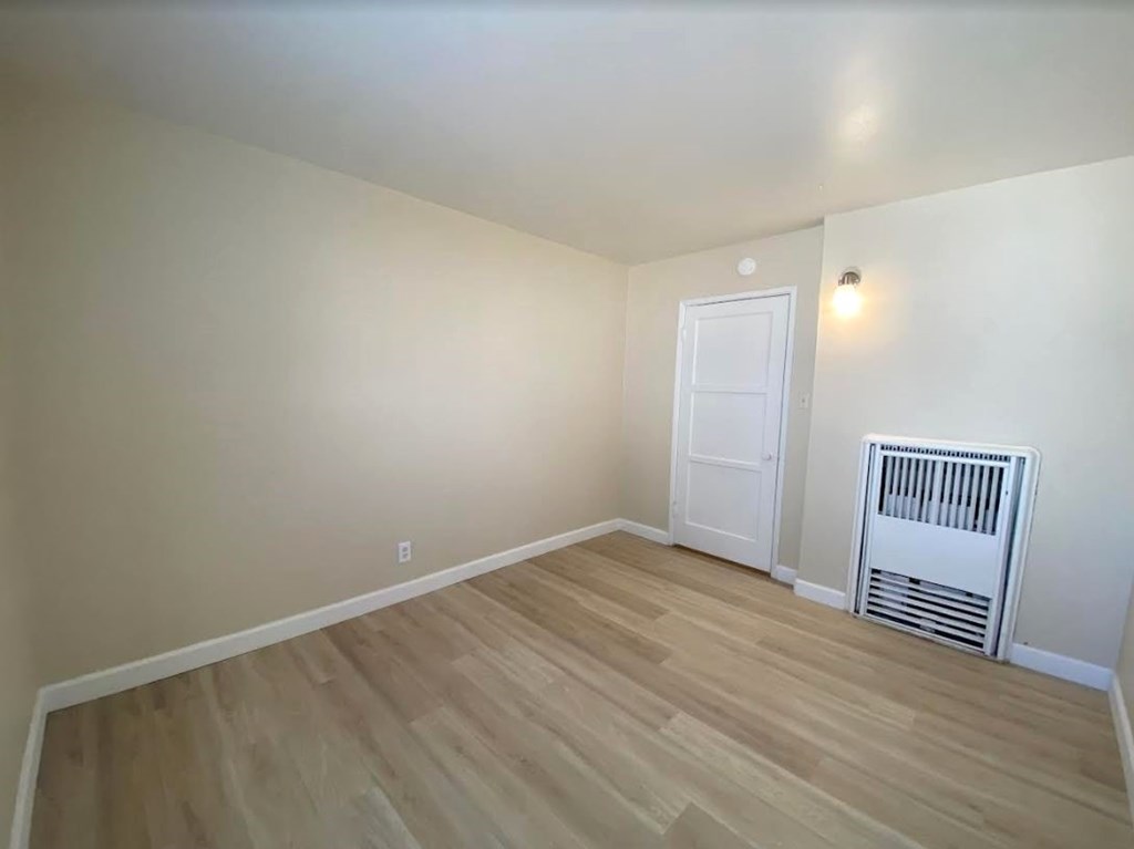 A room with a white door and a white heater.