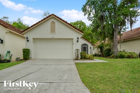 a white house with a white garage door and a driveway
