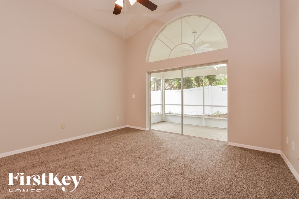 the living room of an empty house with carpet and a large window