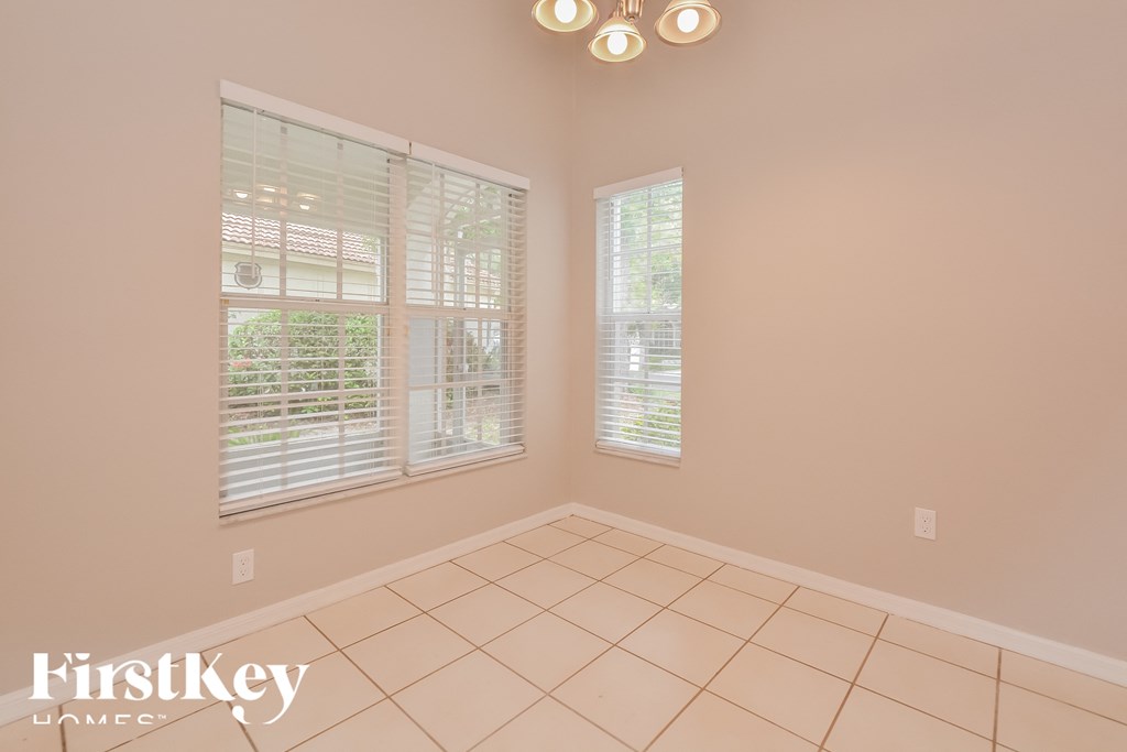 a living room with two windows and a tiled floor