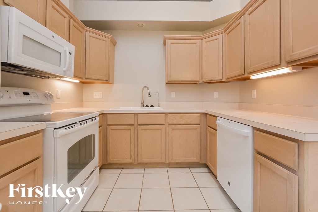 a kitchen with white appliances and wooden cabinets