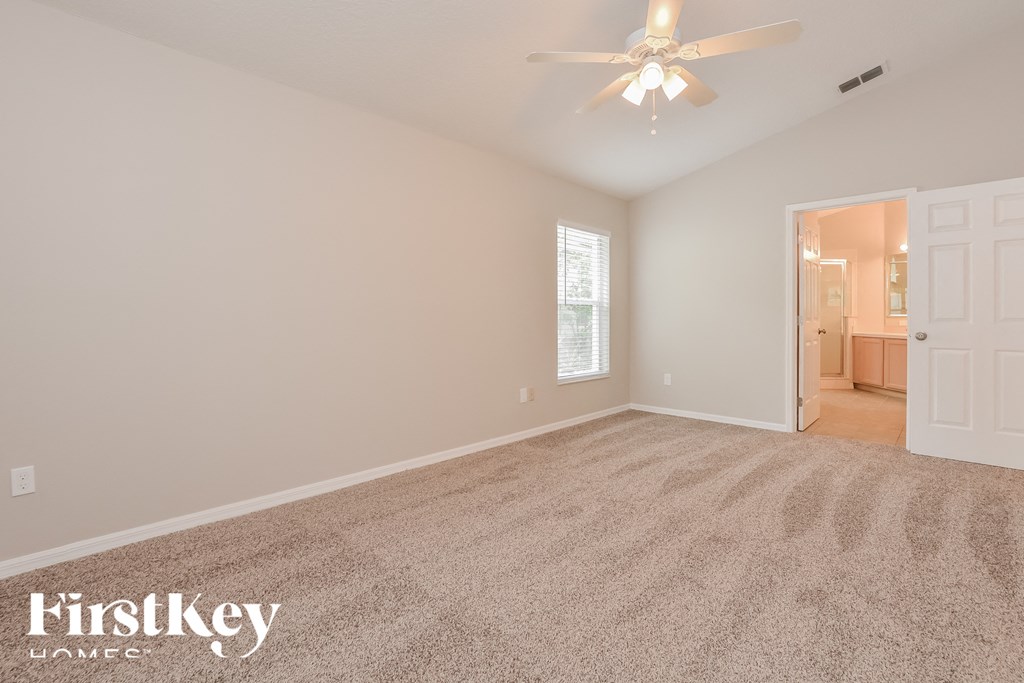 the spacious living room with carpeting and a ceiling fan