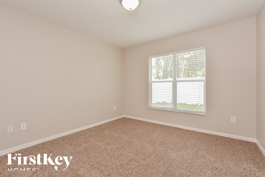 the upstairs bedroom has carpet and a large window