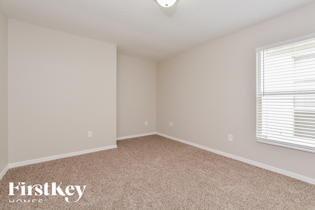a bedroom with a carpeted floor and a window