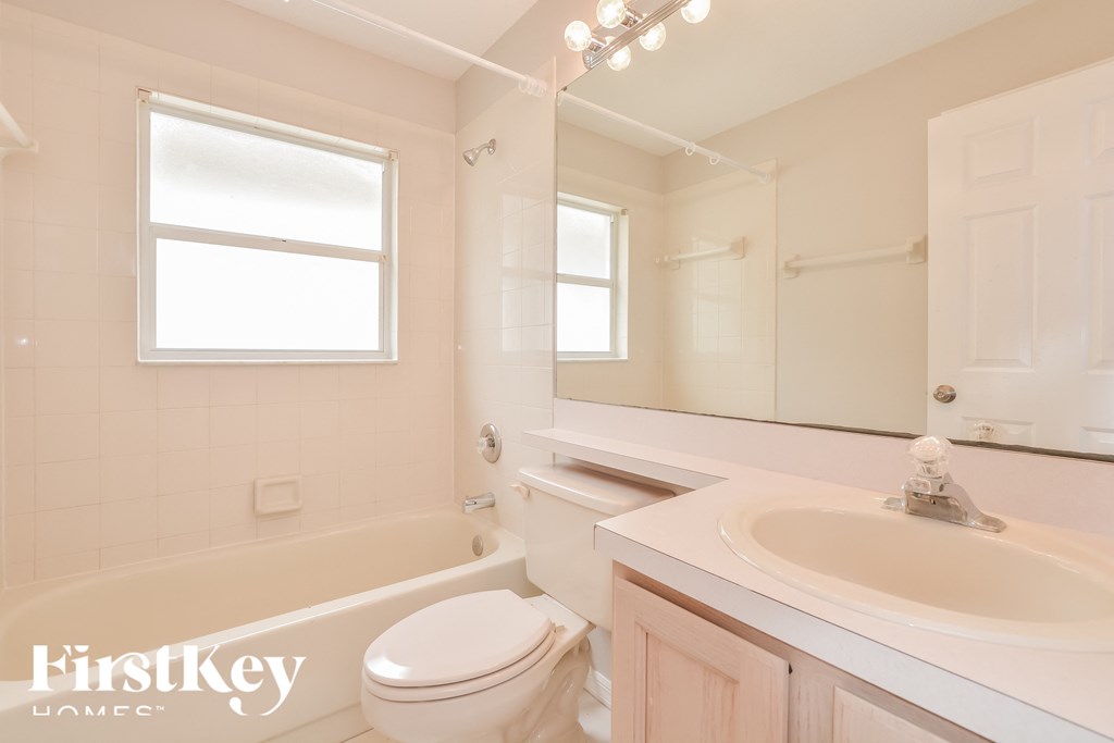 a white bathroom with a sink toilet and tub