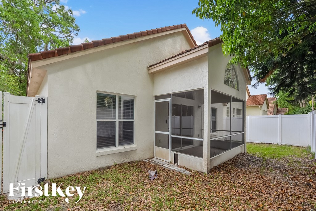 a small white house with a yard and a glass door