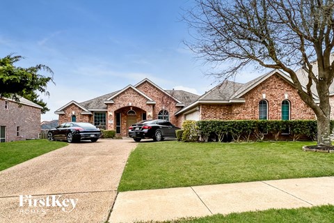 a house with a driveway and cars parked in front of it