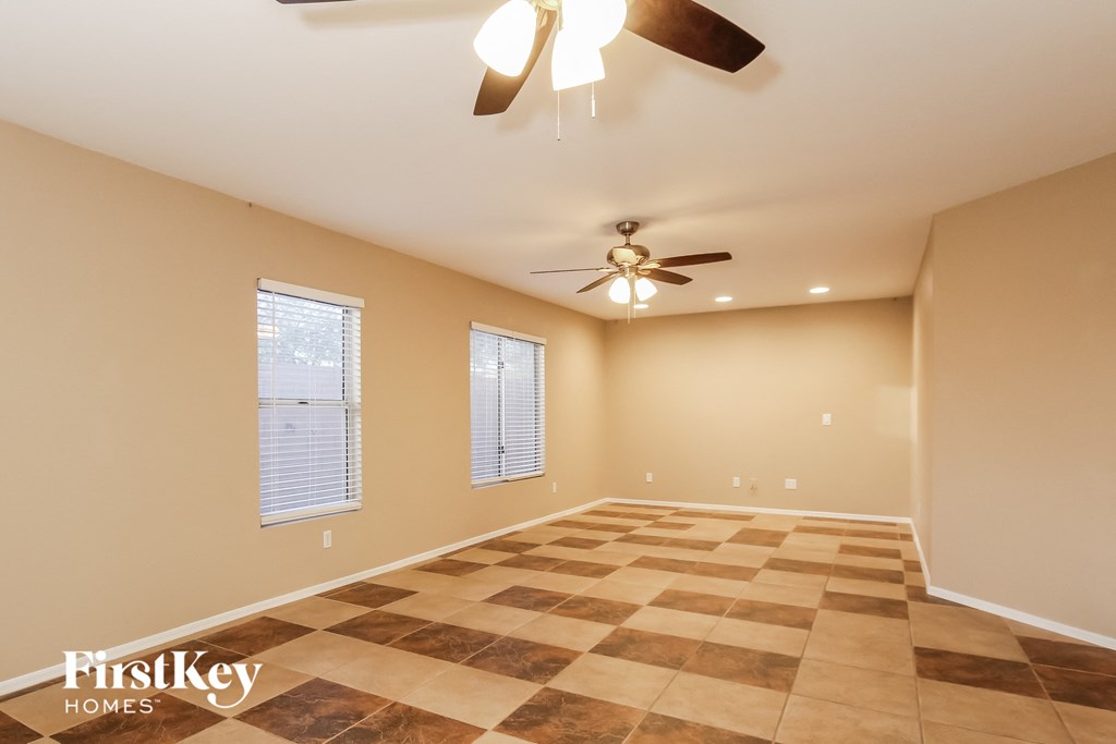 a living room with a ceiling fan and a checkered floor