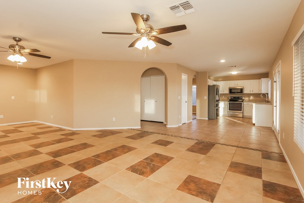 a kitchen and living room with tile flooring and a ceiling fan