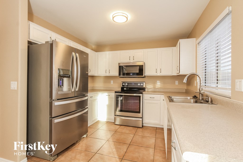 a kitchen with stainless steel appliances and white cabinets