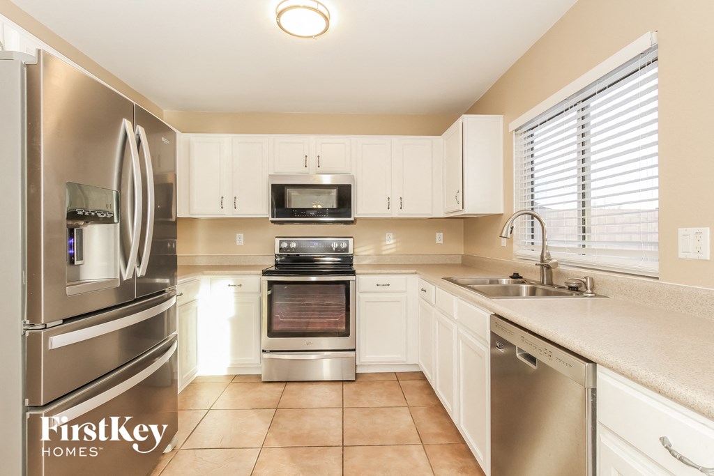 a kitchen with stainless steel appliances and white cabinets