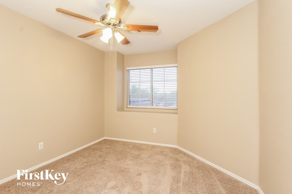 a bedroom with a ceiling fan and a window