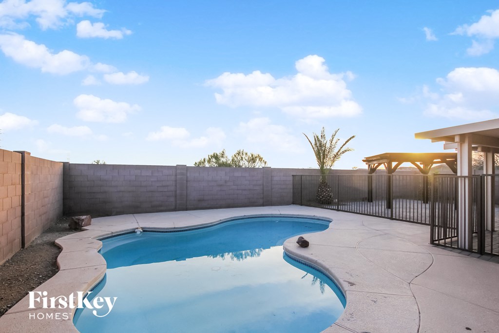 a swimming pool in a backyard with a fence and a house