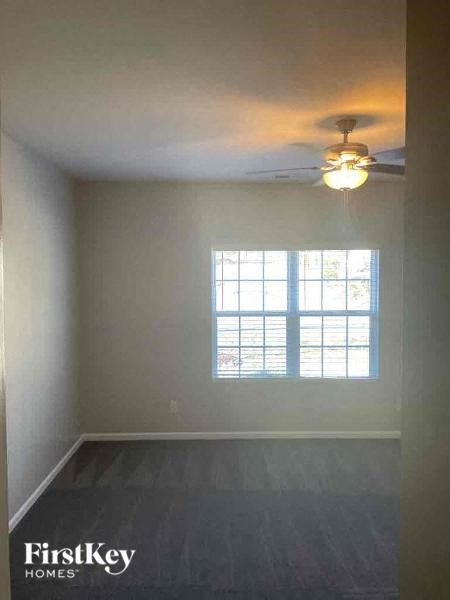 an empty room with a ceiling fan and a window